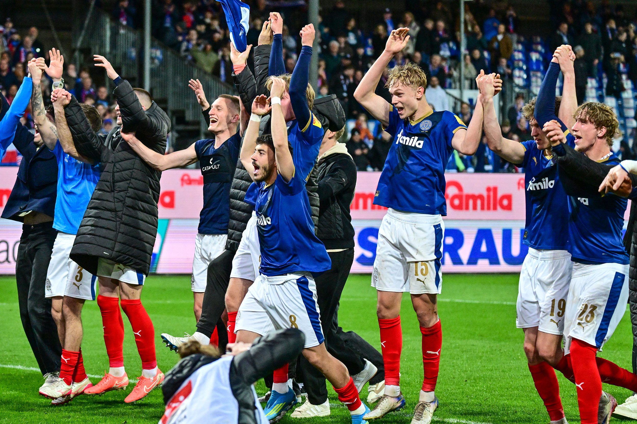 Die Kieler Spieler feiern den Sieg vor der Fankurve